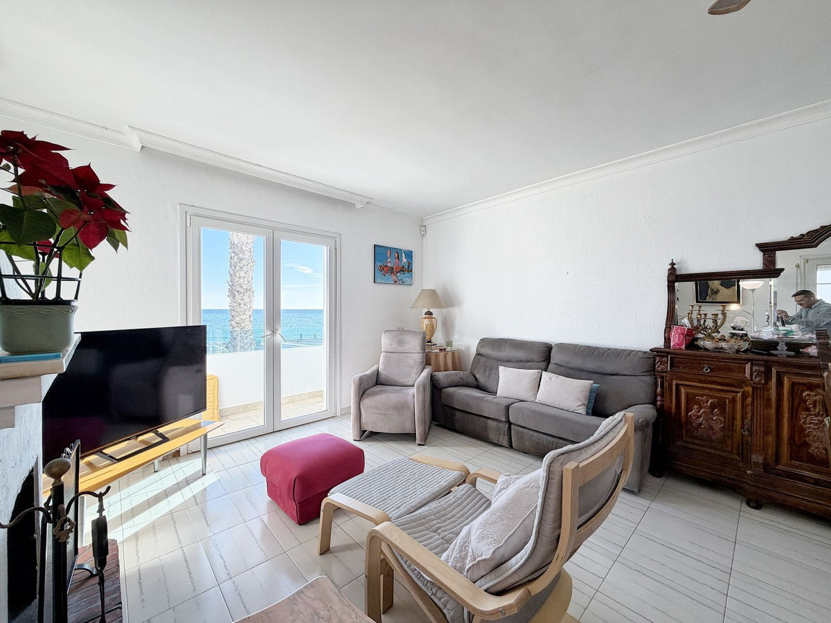 Woonkamer met uitzicht op zee en comfortabele meubels.