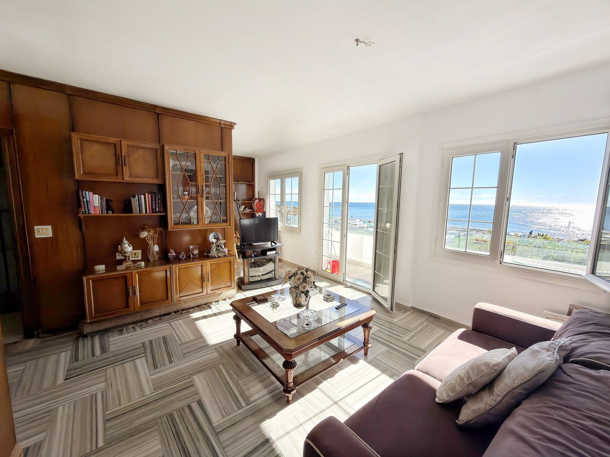 Woonkamer met houten kasten en uitzicht op zee