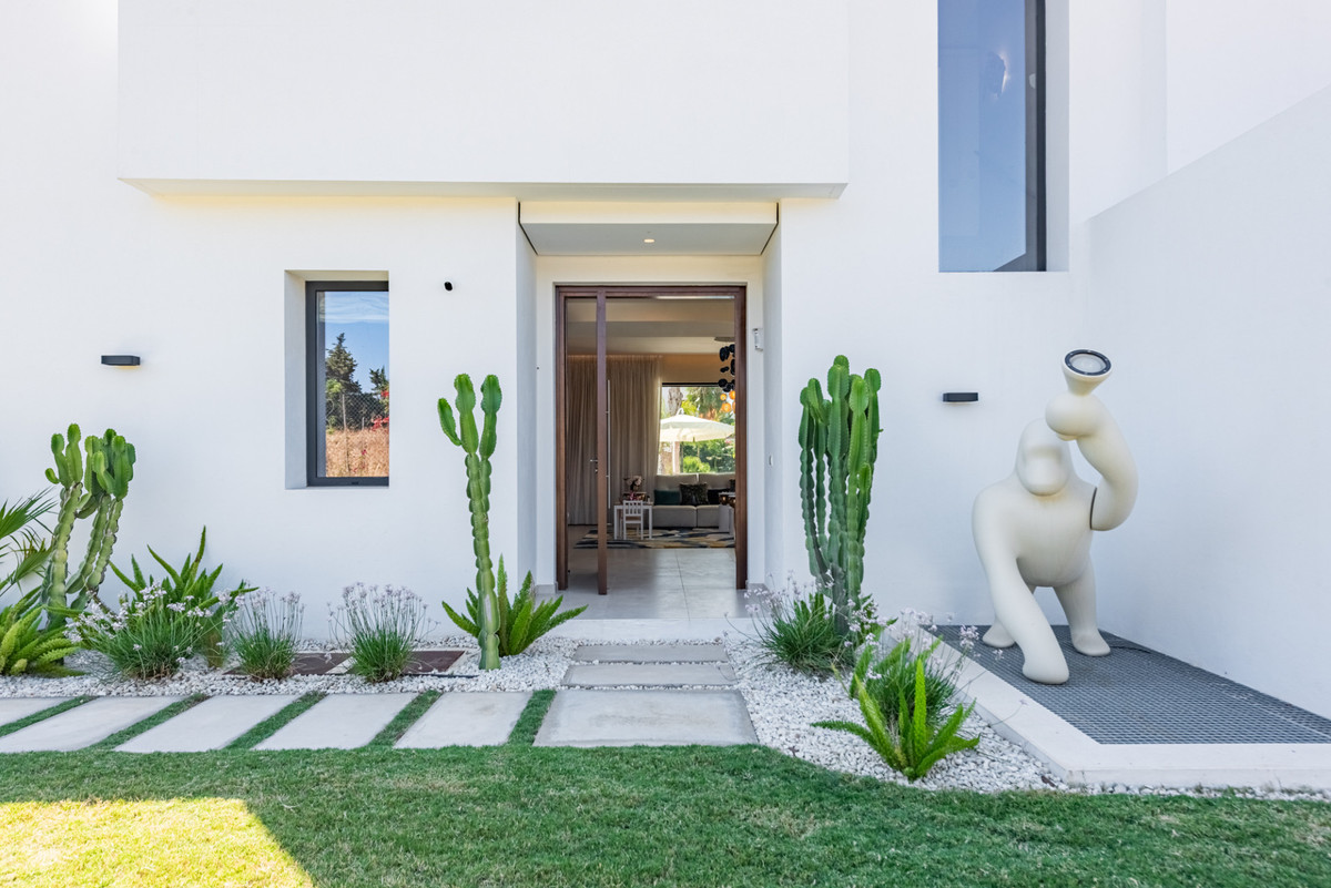 Moderne villa entree met tuin en kunstwerk.