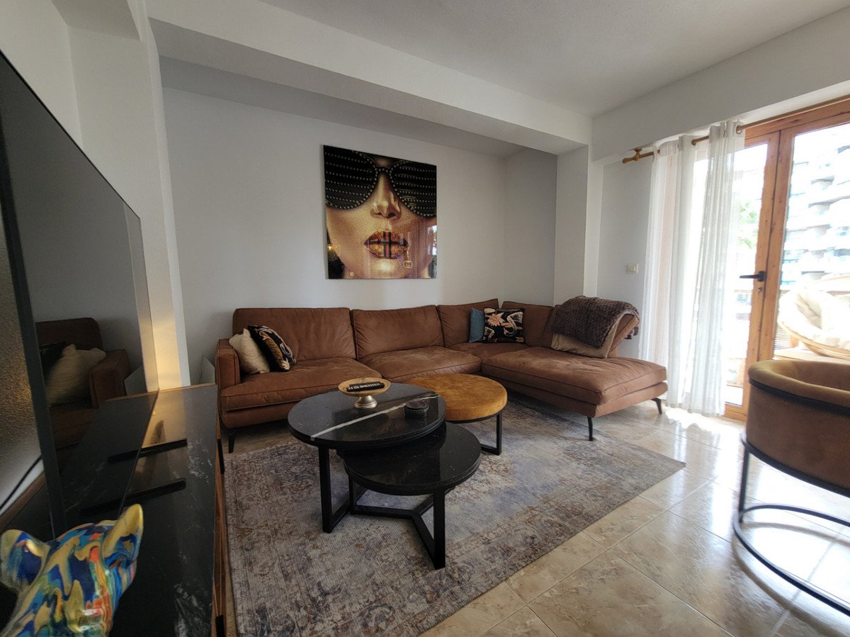 Modern living room with a large brown sectional sofa, unique artwork, and a glass door leading to an outdoor area.