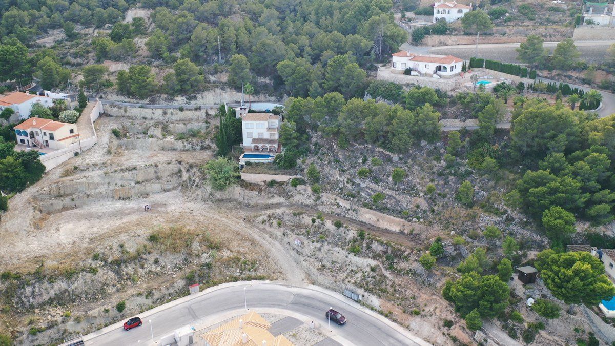 Luchtfoto van een woning met zwembad op een heuvel.