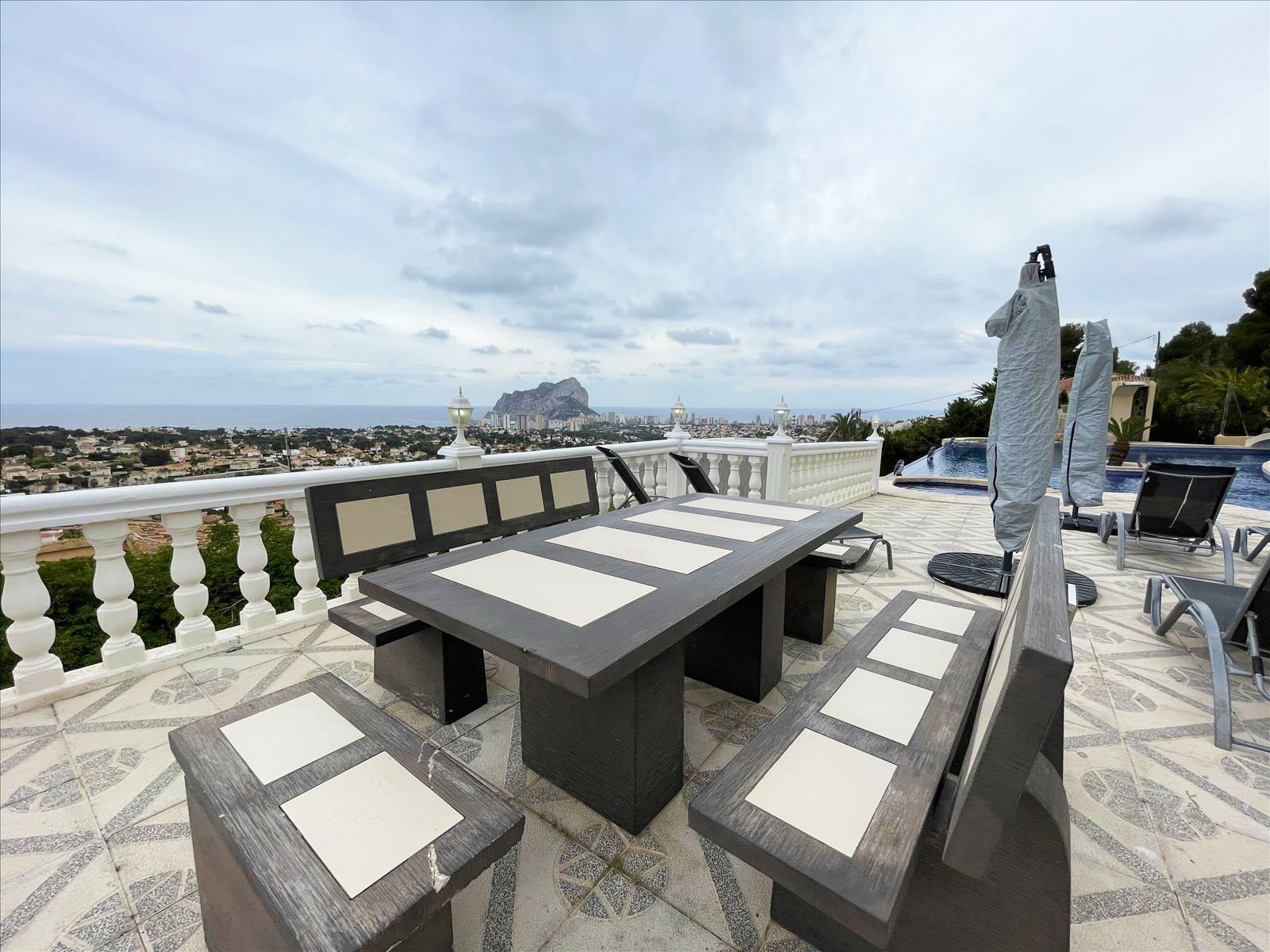 Terras van villa met buitentafel en uitzicht.