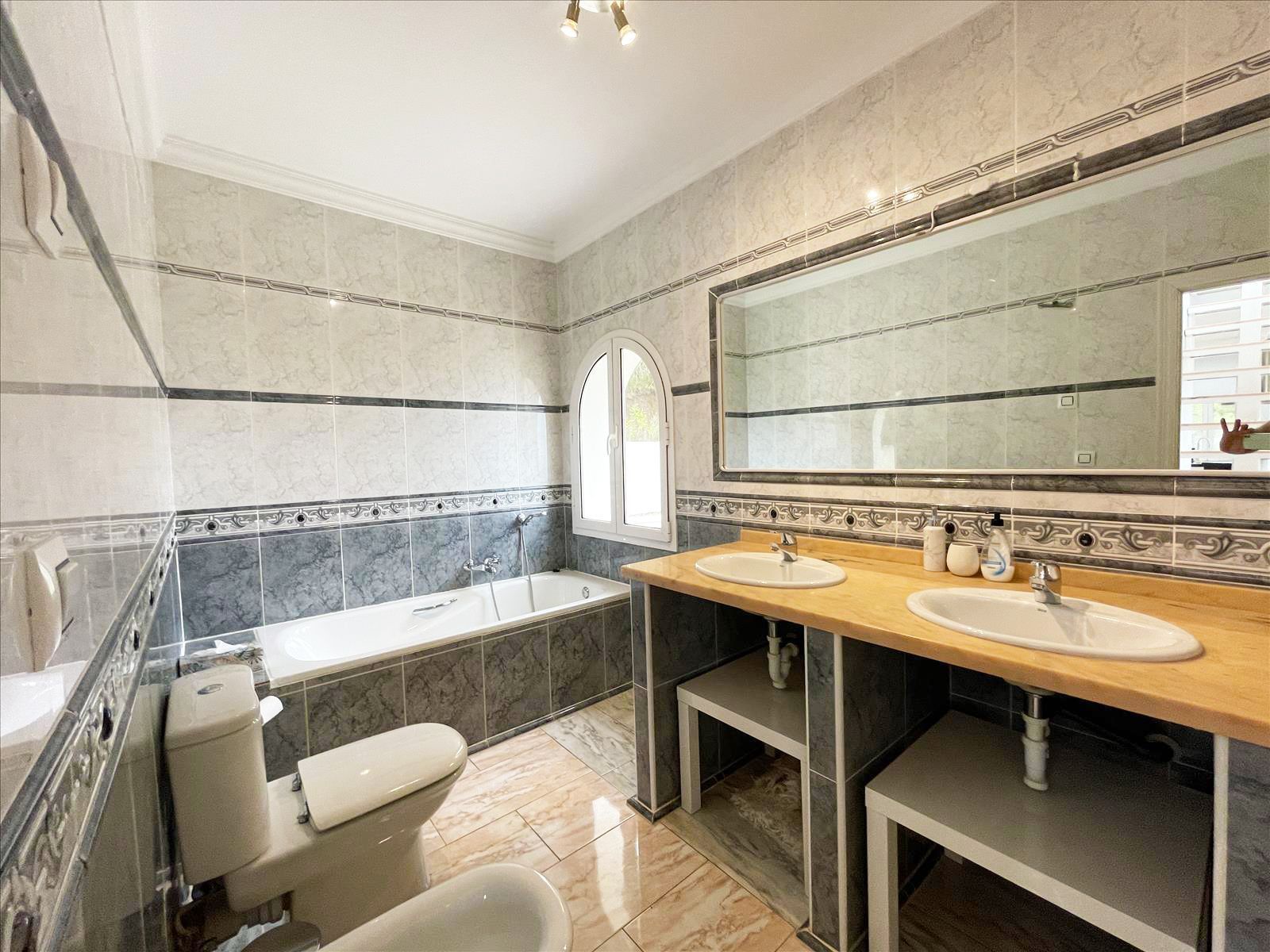 Badkamer met ligbad en dubbele wastafel