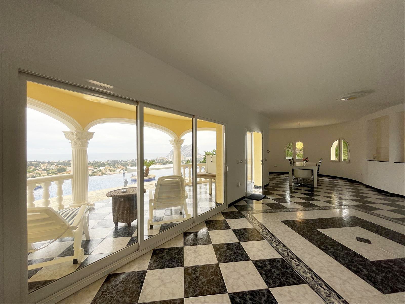 Luxe interieur met uitzicht op zwembad en zee.