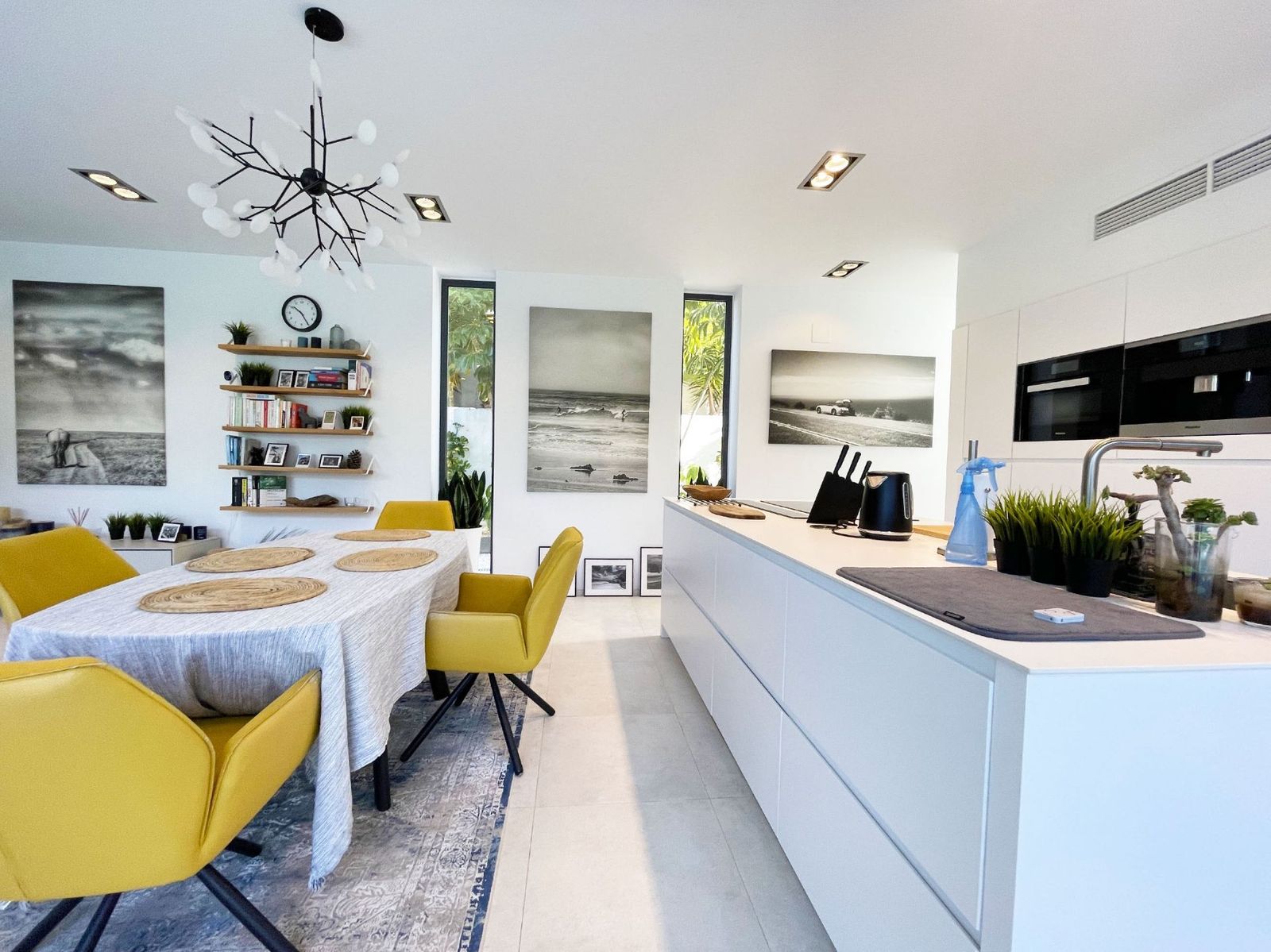 Moderne keuken en eetkamer met gele stoelen en kunst