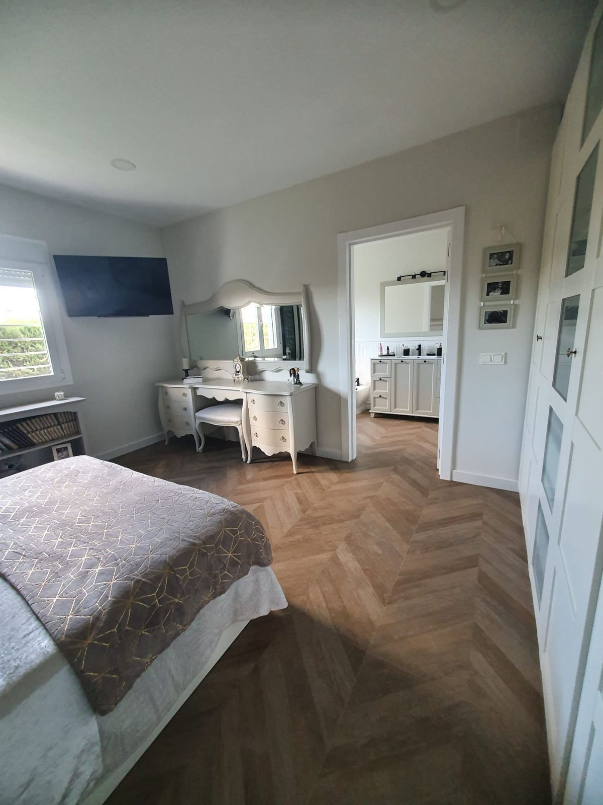 Slaapkamer met kaptafel en doorkijk naar de badkamer