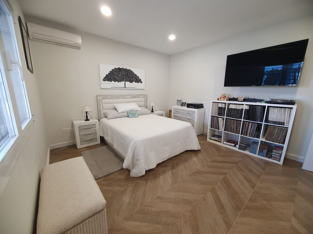 Moderne slaapkamer met wit interieur en tv.