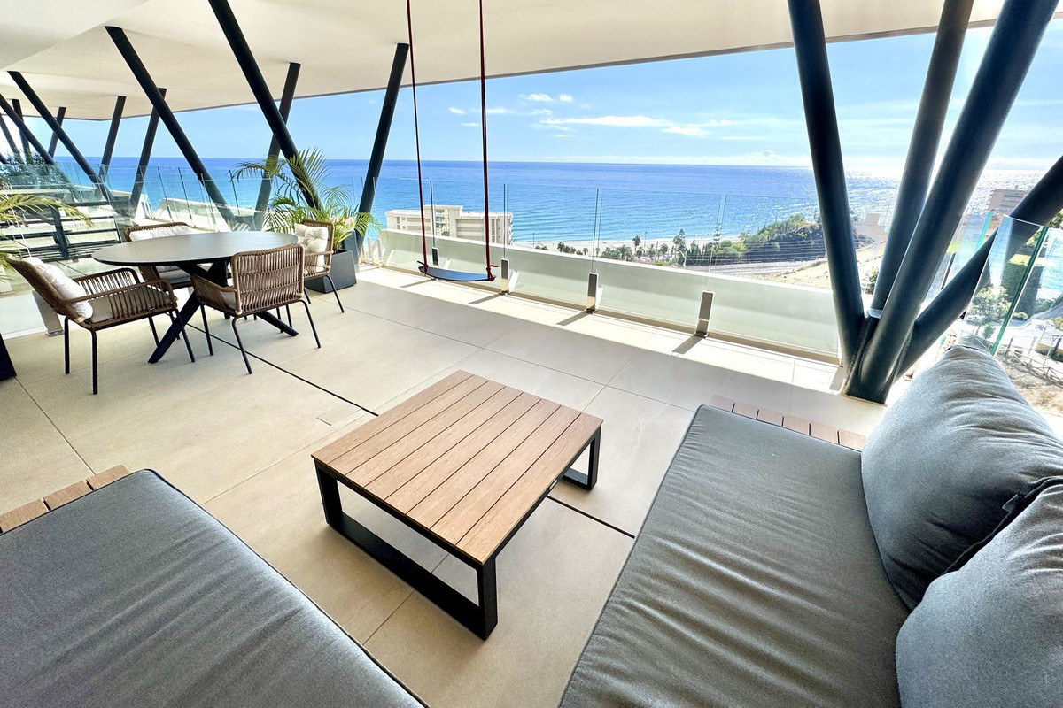 Terras met uitzicht op de oceaan, voorzien van zitmeubels en een tafel.