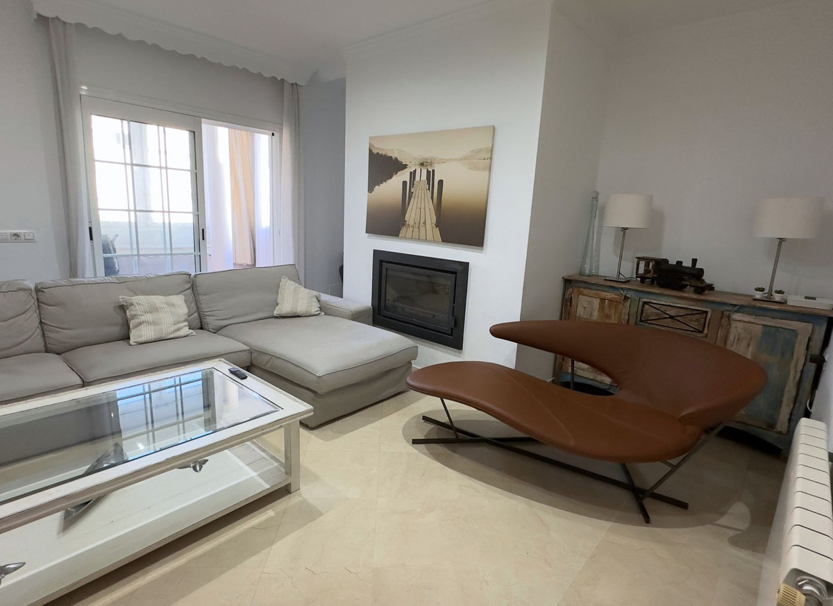 Moderne woonkamer met open haard, grijze bank en bruine stoel