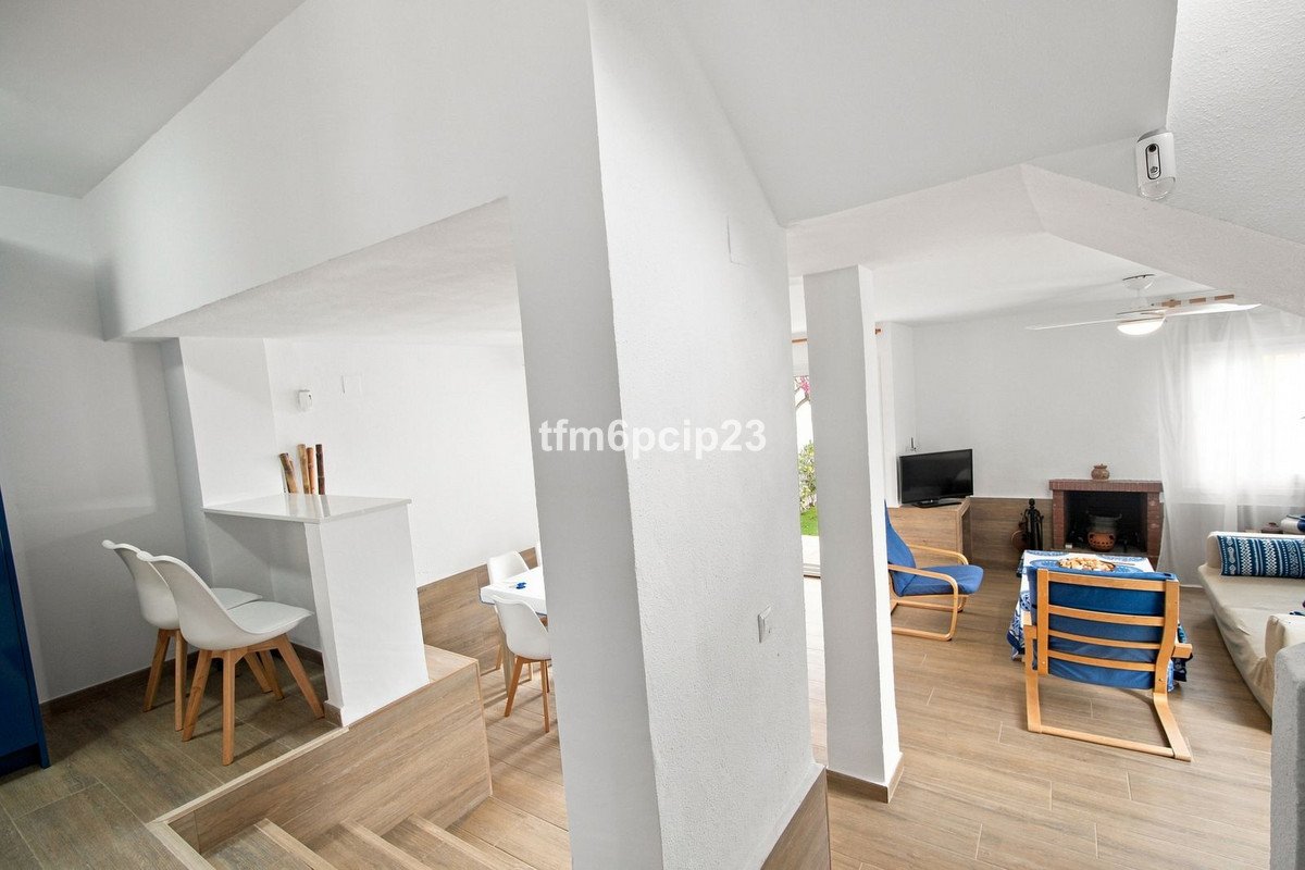 Spacious living area with a dining nook, fireplace, television, and comfortable seating. Modern design with light wood floors.
