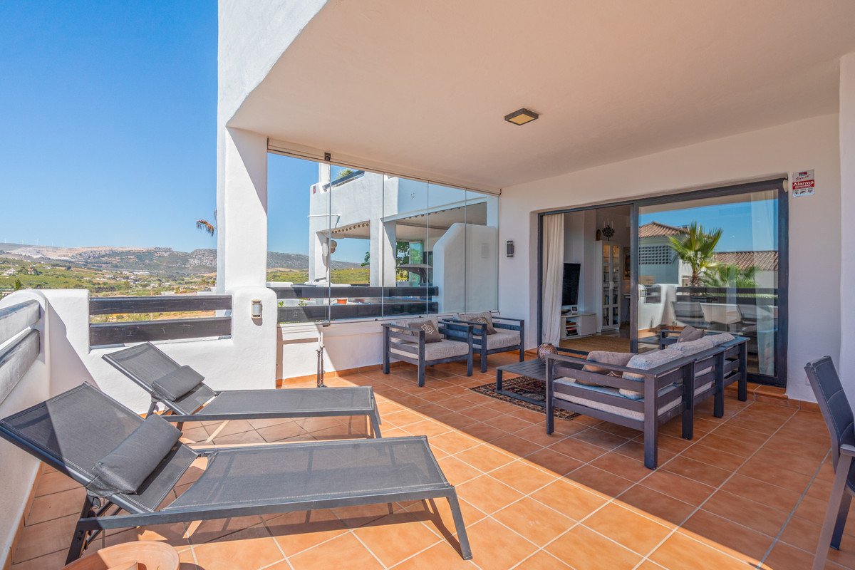 Spacious terrace with lounge chairs, comfortable seating area, and panoramic views of the landscape and distant sea.