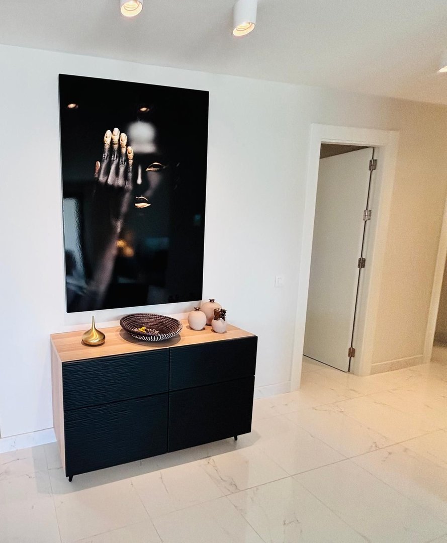 Modern living room featuring a black and white artwork above a sleek black and wood console table