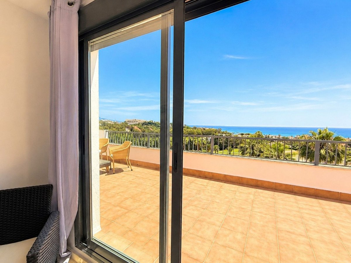 Spacious balcony with terrace seating and a beautiful sea view under a clear blue sky.