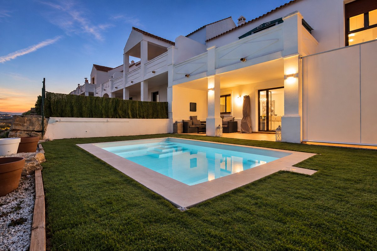 Modern villa with a private swimming pool, a covered terrace with seating, and garden view at dusk.