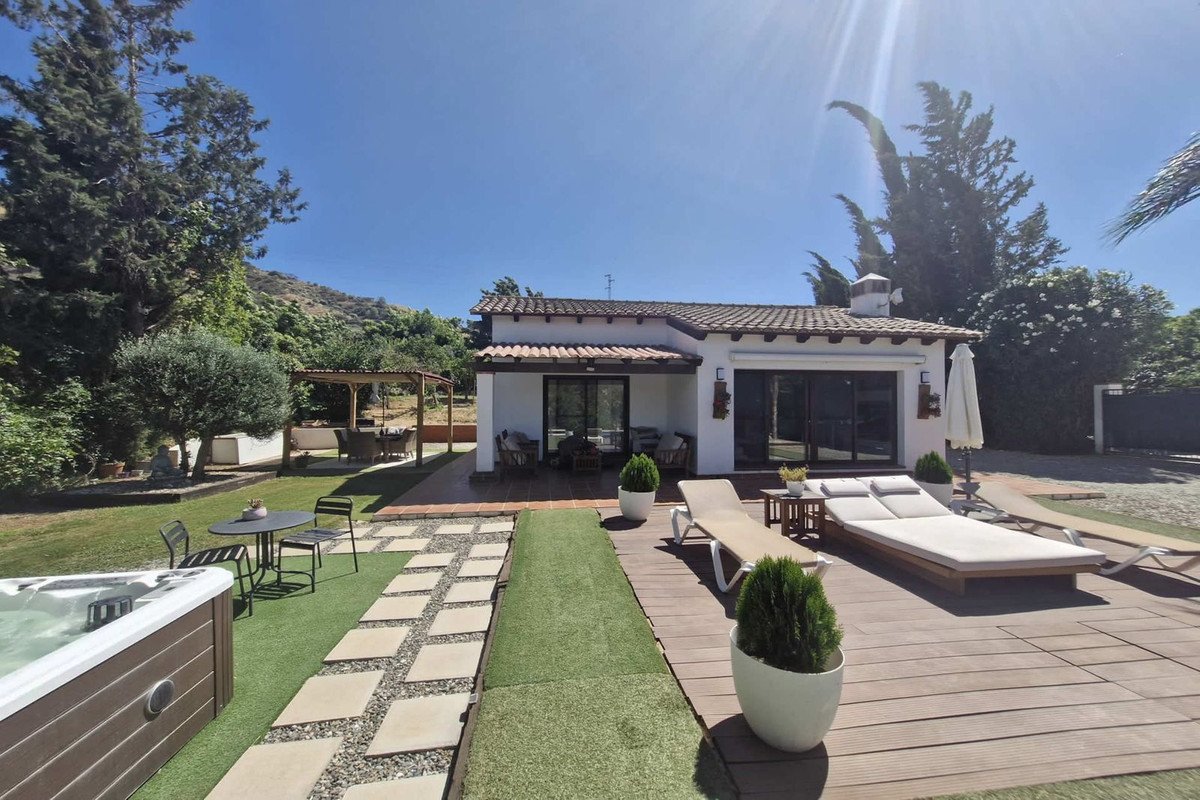 Modern outdoor lounge with swimming pool and sun loungers under clear blue sky