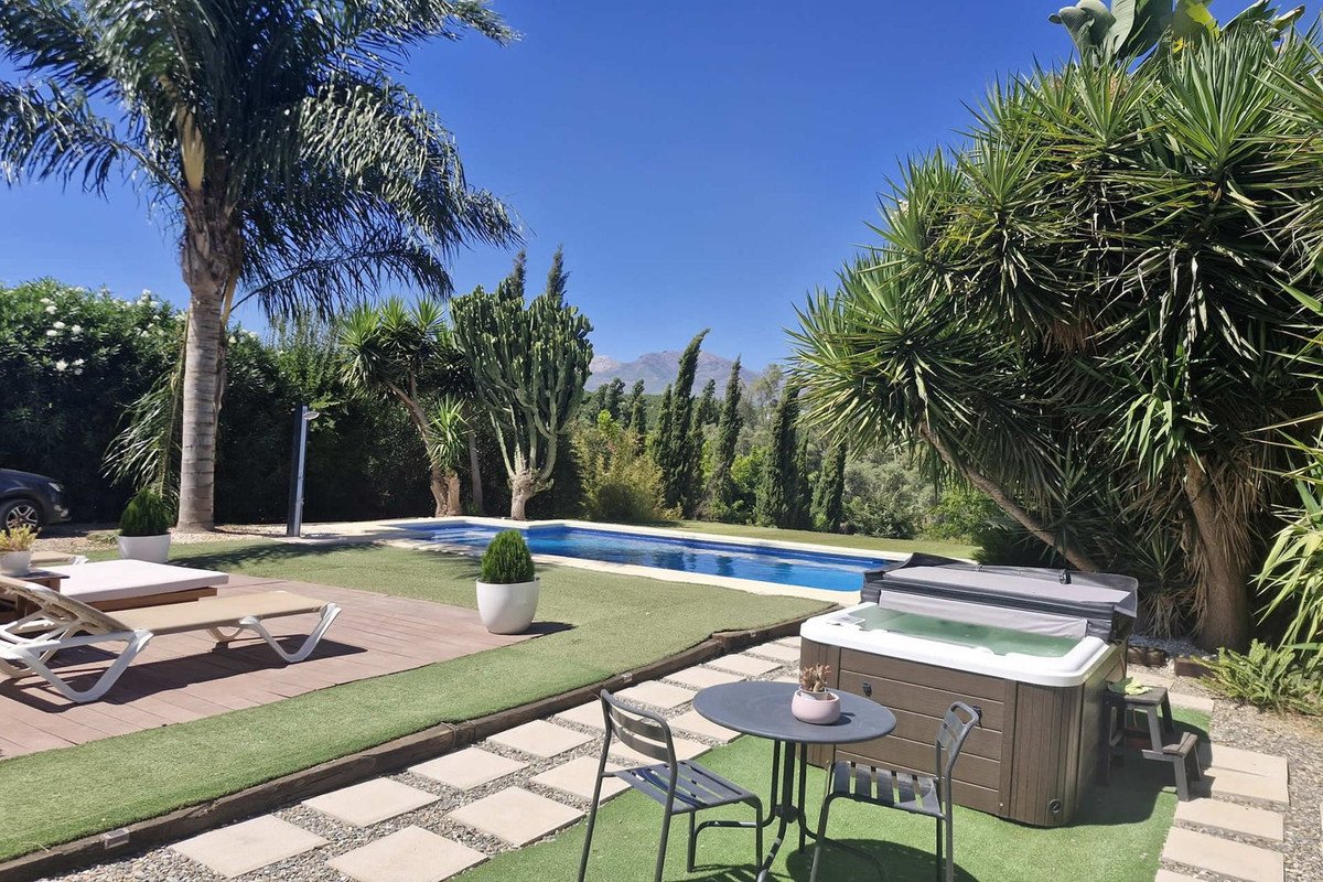 Luxurious swimming pool with tropical garden and outdoor seating area