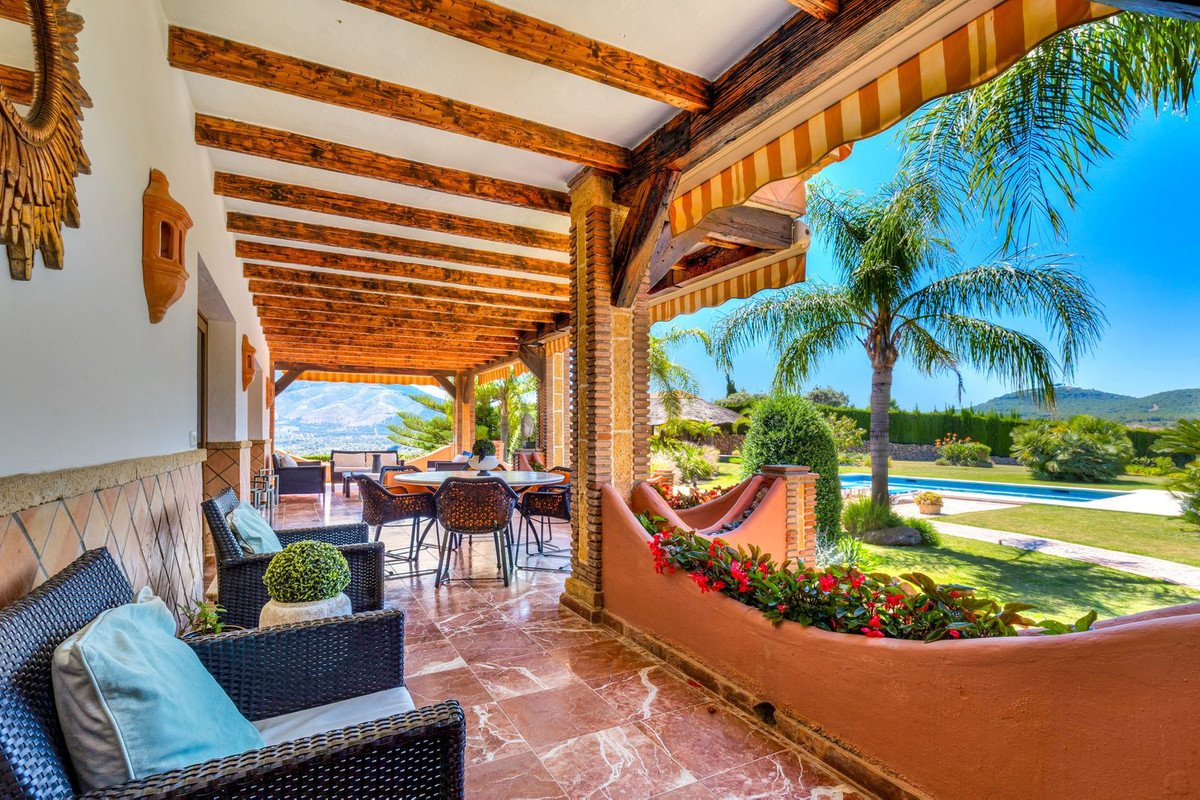 Covered patio with pool and garden view