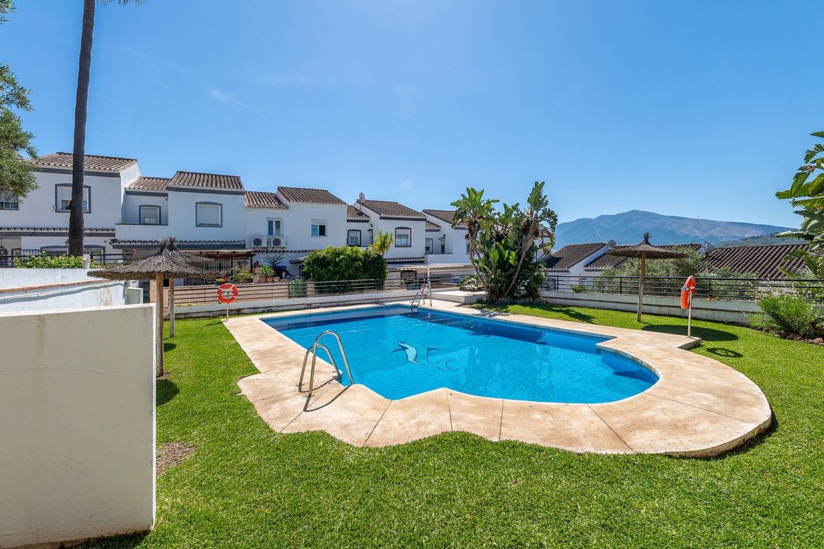 Swimming pool with lake view surrounded by green lawn and white houses