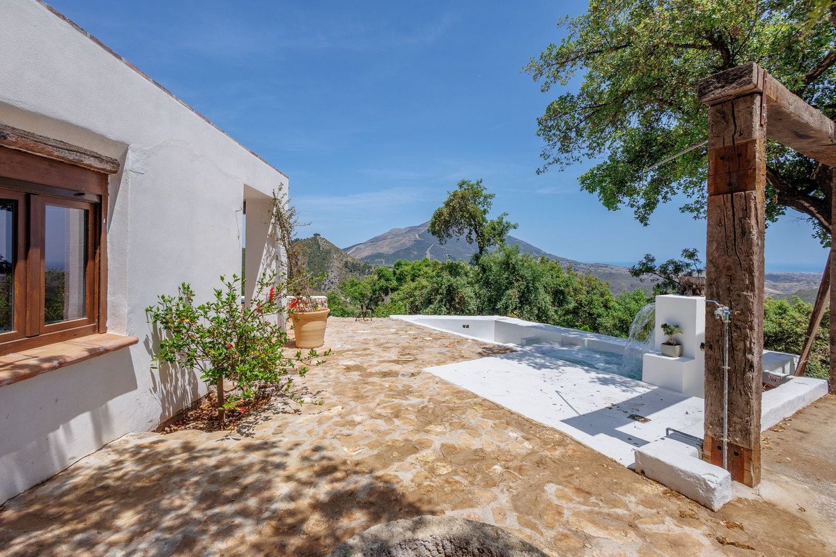 Terrace with pool, outdoor shower, and mountain views from white villa.