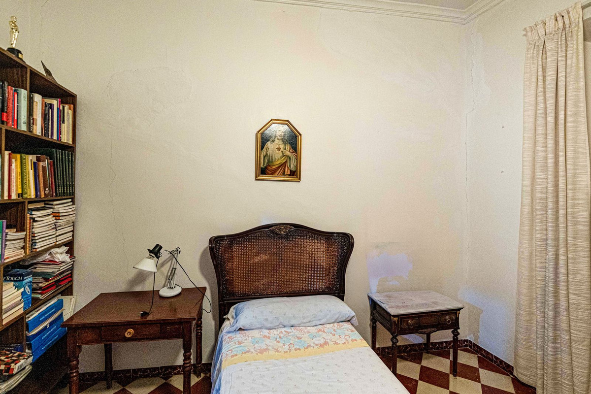 Vintage slaapkamer met boekenkast, bed en decoratie.