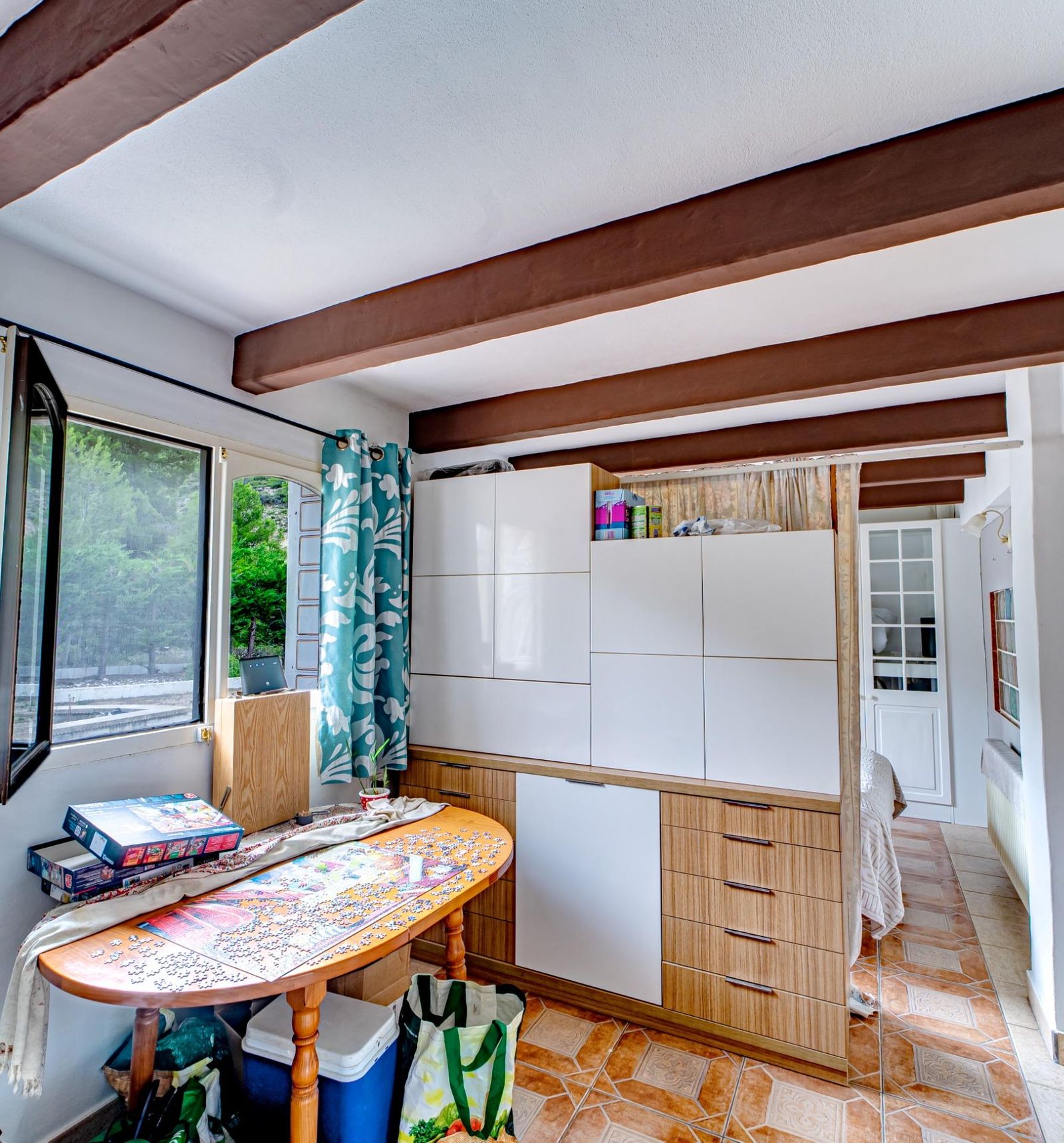 Gezellige kamer met puzzeltafel en uitzicht naar buiten.