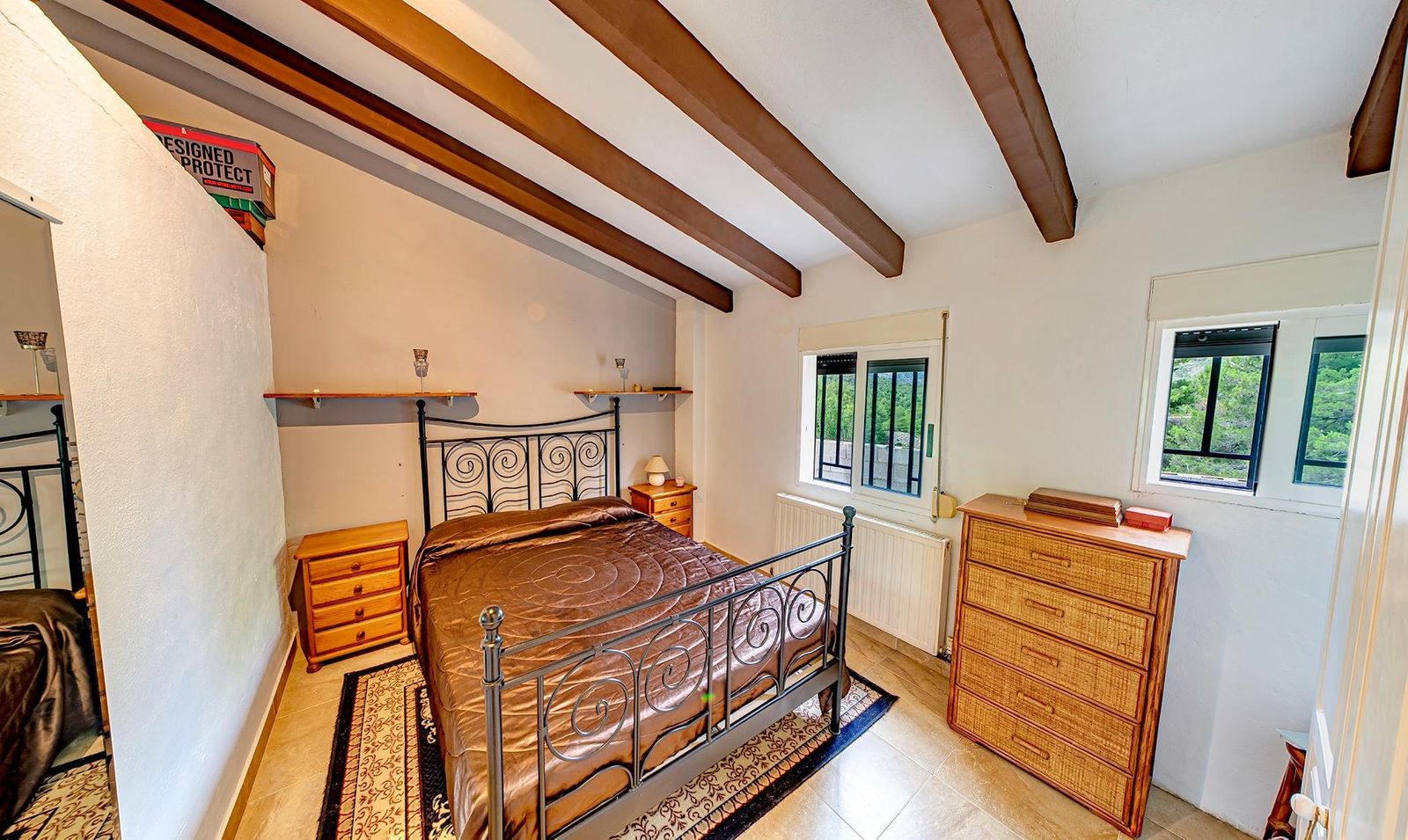 Gezellige slaapkamer met houten balken en decoratieve meubels.