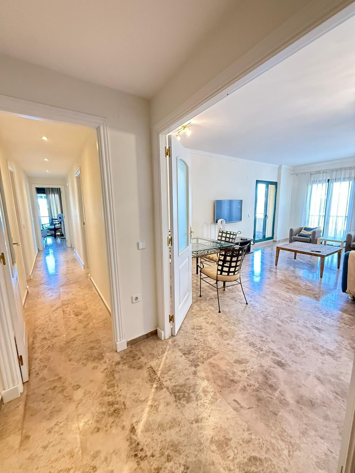 Doorkijk van hal naar woonkamer in een appartement.