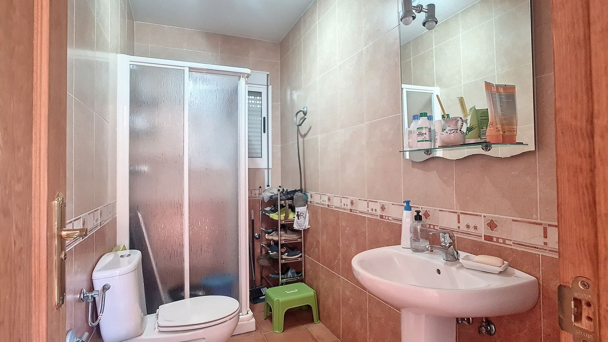 Functionele badkamer met douche, toilet en wastafel.