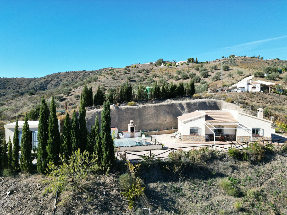 Overzicht van een Andalusische villa met zwembad en landschap.