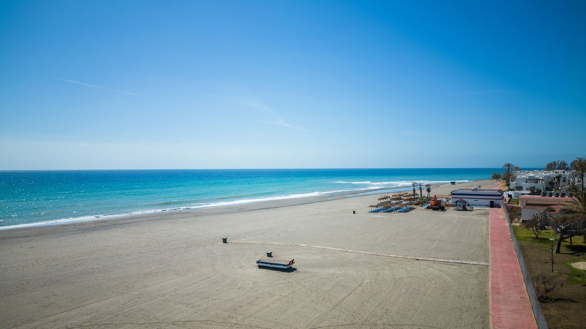 Strandscène met helderblauwe lucht en turquoise zee.