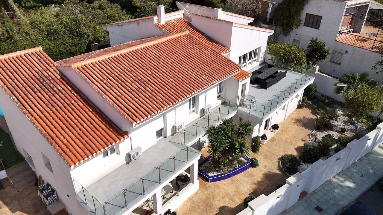 Luxe villa met oranje dakpannen, gezien vanuit de lucht.