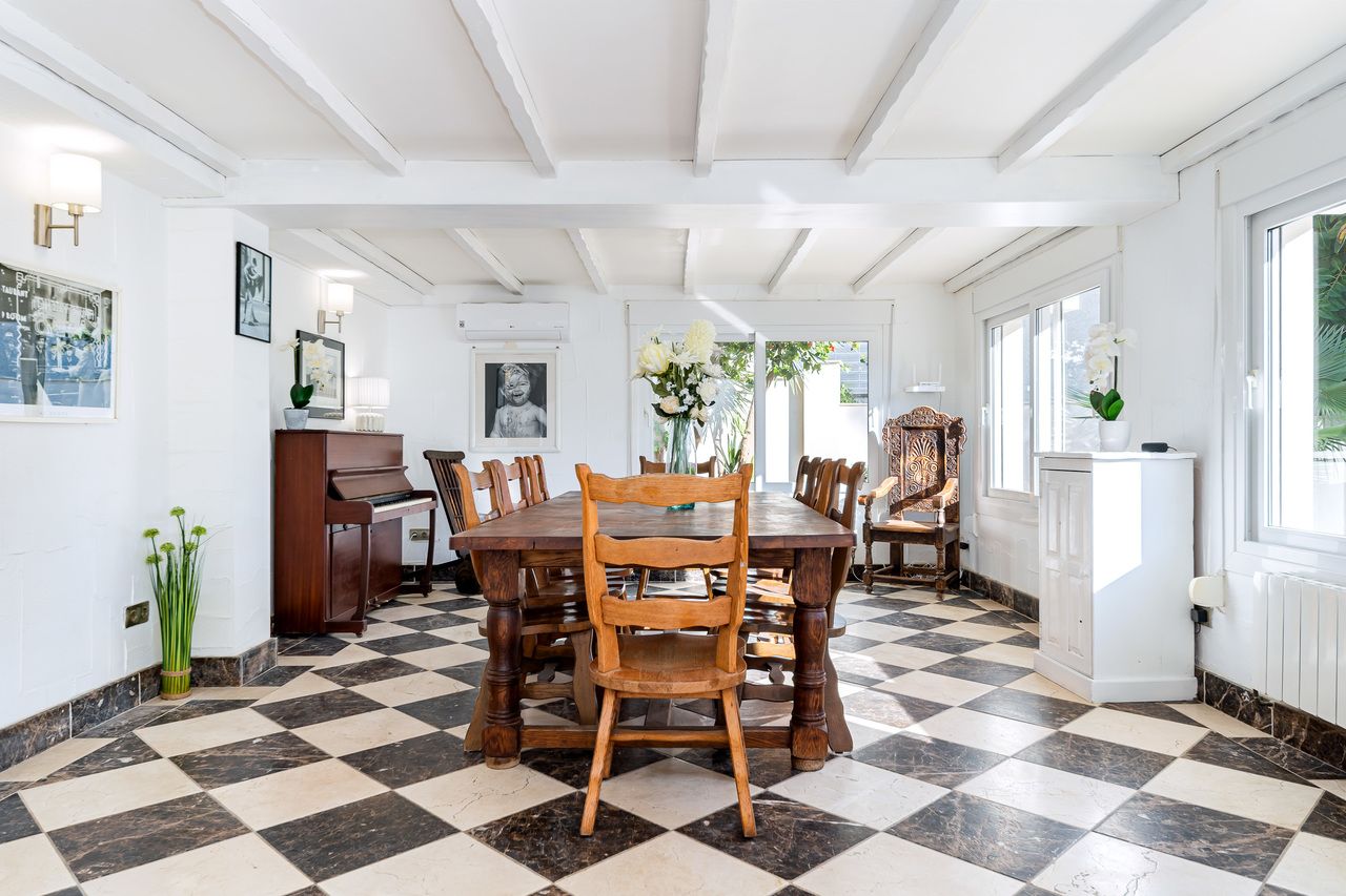 Eetkamer met piano en zwart-wit geblokte vloer.