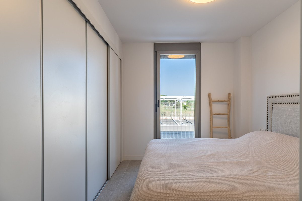 A bedroom featuring a large sliding door closet, a bed, and a view of a swimming pool and outdoor area.