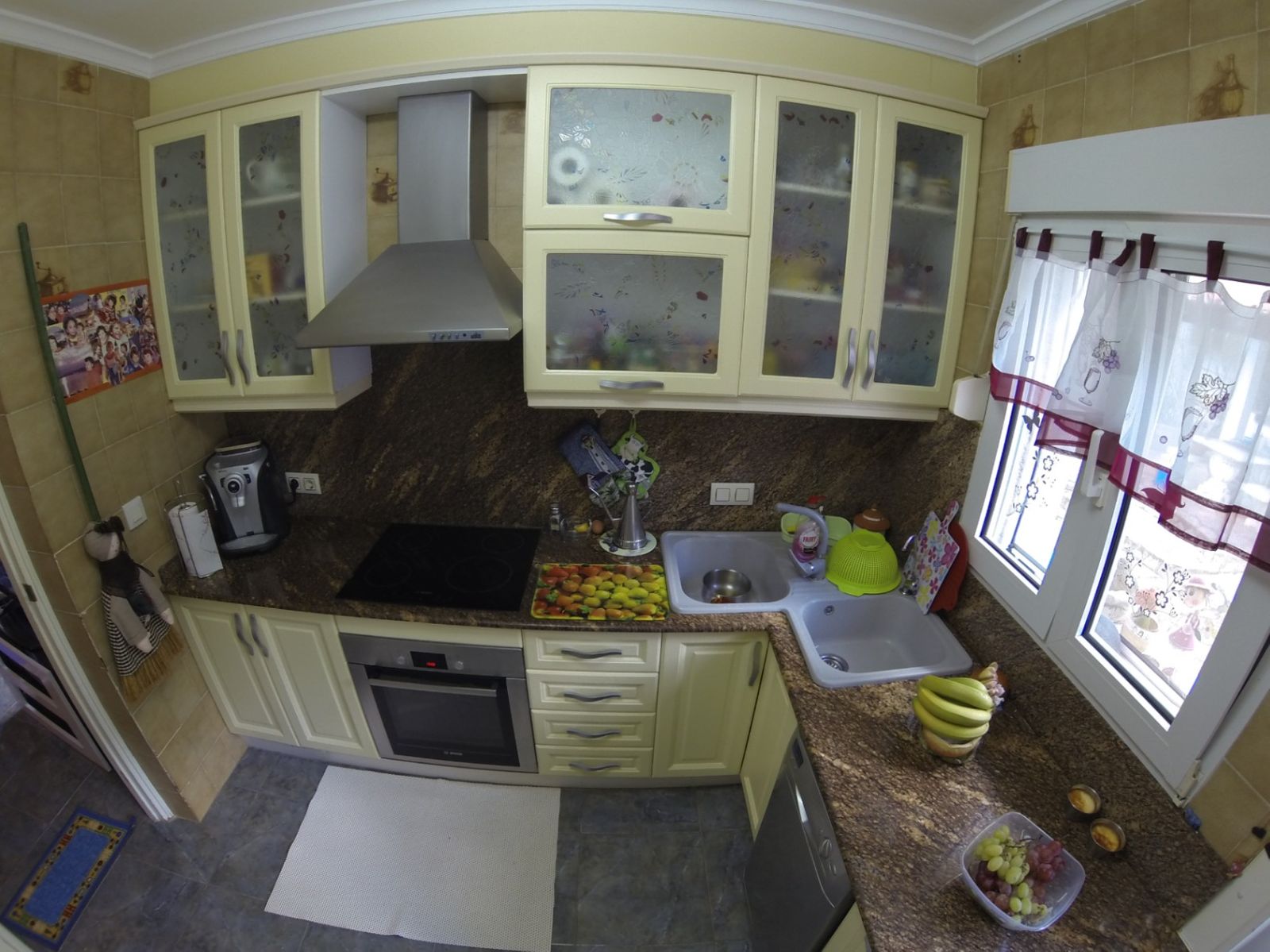 Gezellige keuken met raam en fruitmanden.