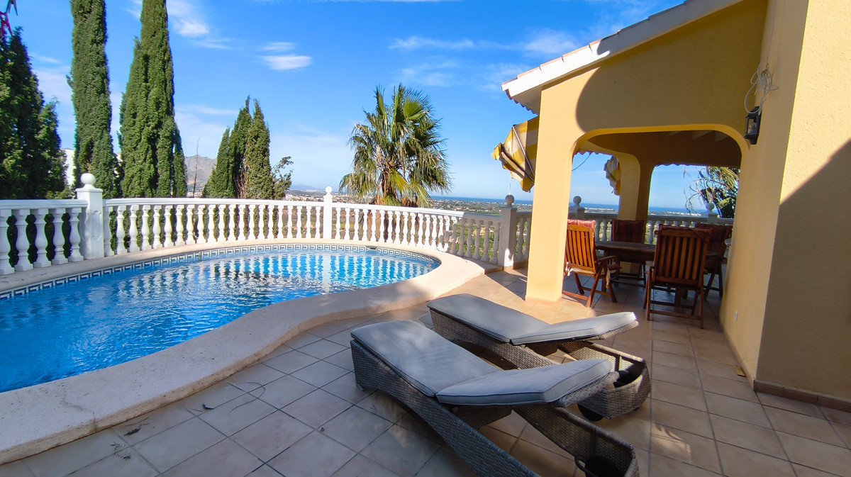 A private pool with sun loungers and a covered outdoor dining area overlooking the sea.