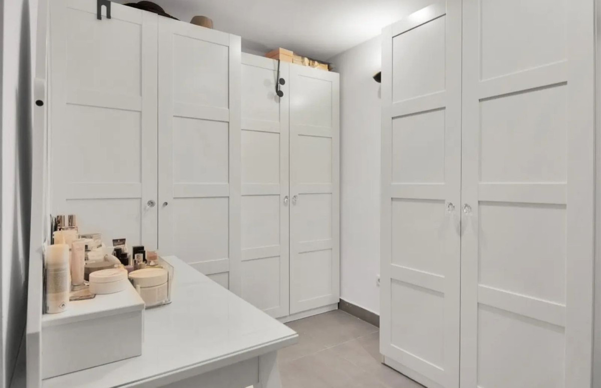 Witte kledingkast en kaptafel in een dressing area.