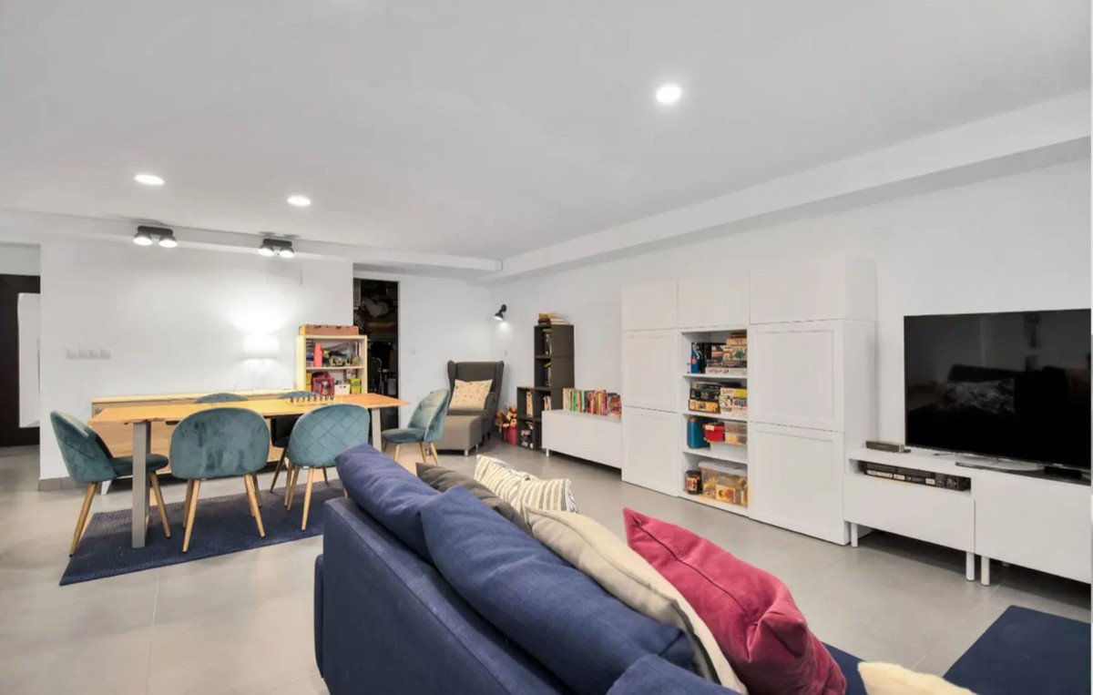 Moderne woon- en eetkamer met blauwe bank en eettafel met groene stoelen.