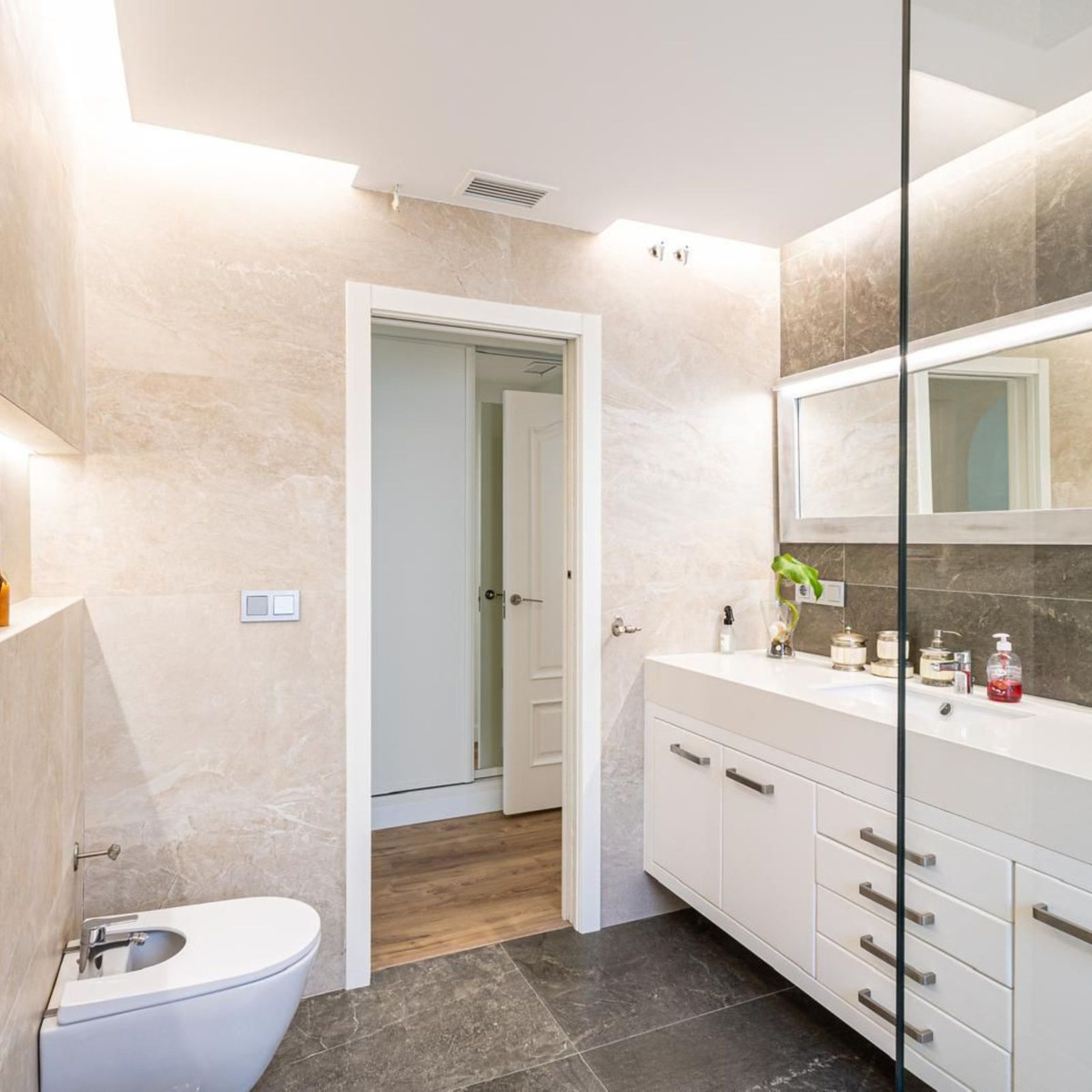 Moderne badkamer met bidet, wastafel en spiegel.