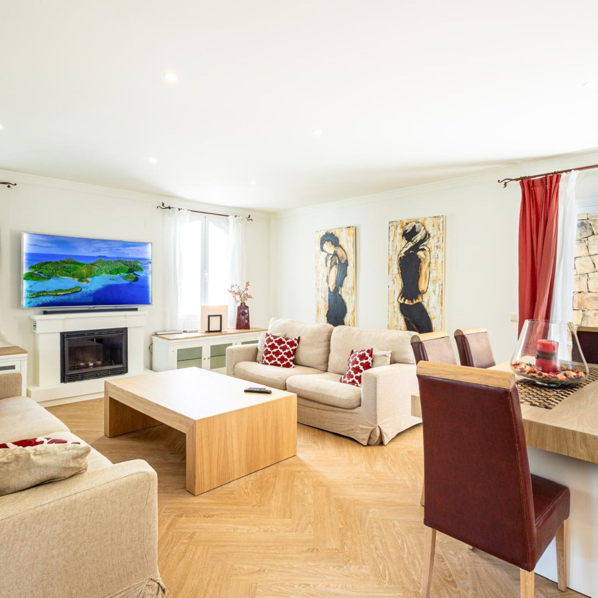 Stijlvolle woonkamer met comfortabele banken, open haard en moderne kunst.