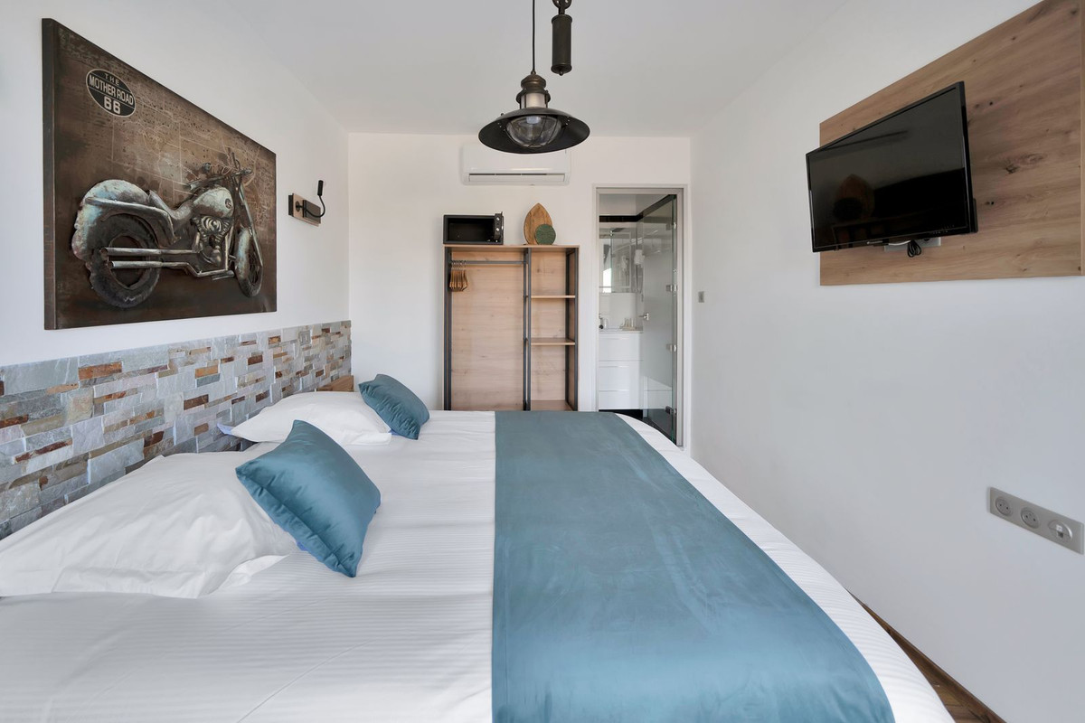 Moderne slaapkamer met motorfietskunst aan de muur en badkamer en suite.