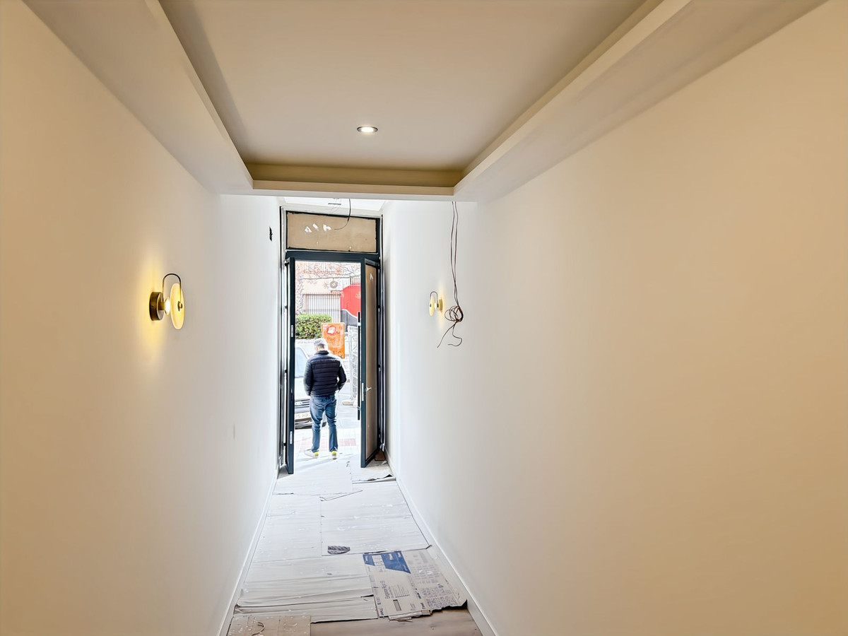 Hal in aanbouw met man die naar buiten loopt