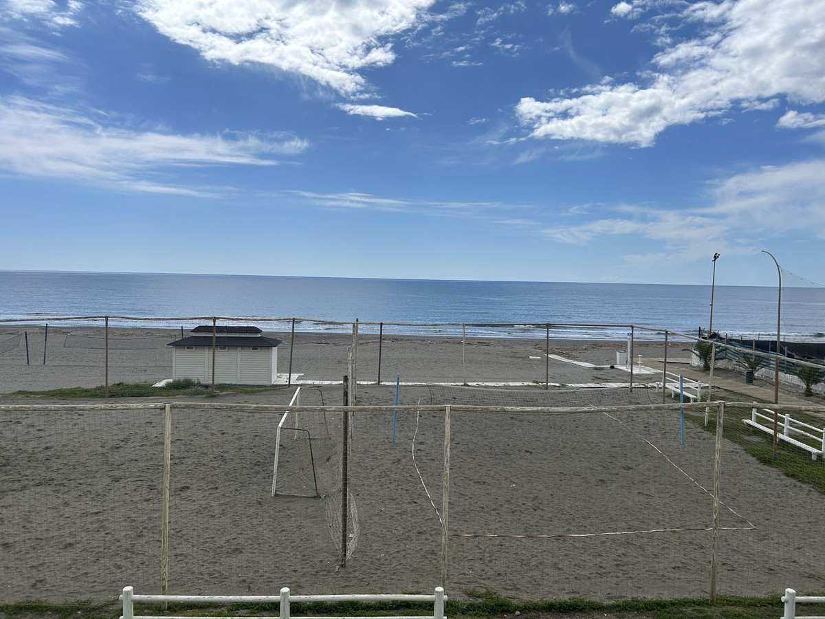 Strandvolleybalveld met uitzicht op de oceaan op een zonnige dag.