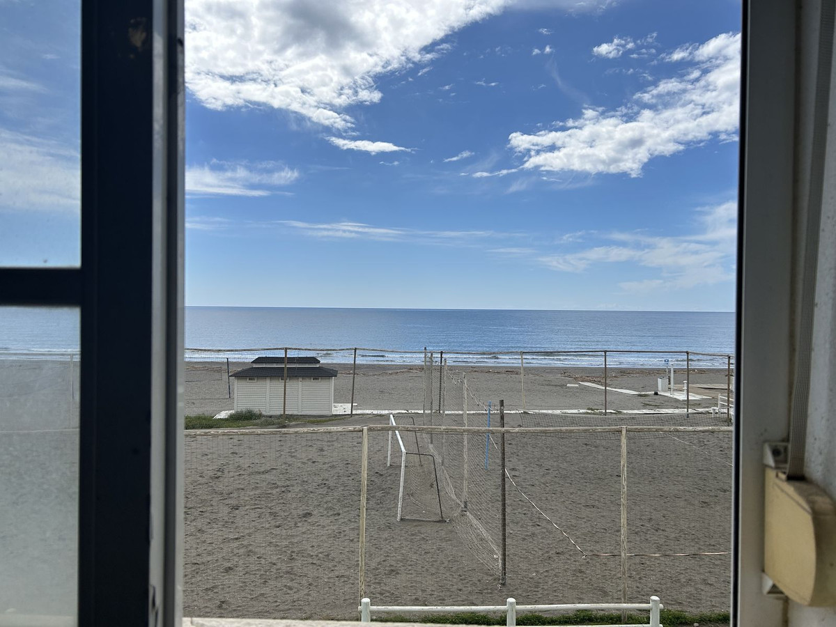Uitzicht op het strand vanuit het raam, met voetbaldoel en kleedkamer.