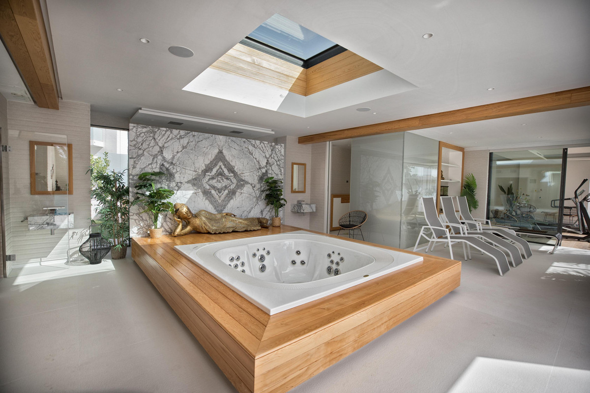 Luxe spa kamer met jacuzzi en Boeddha beeld.