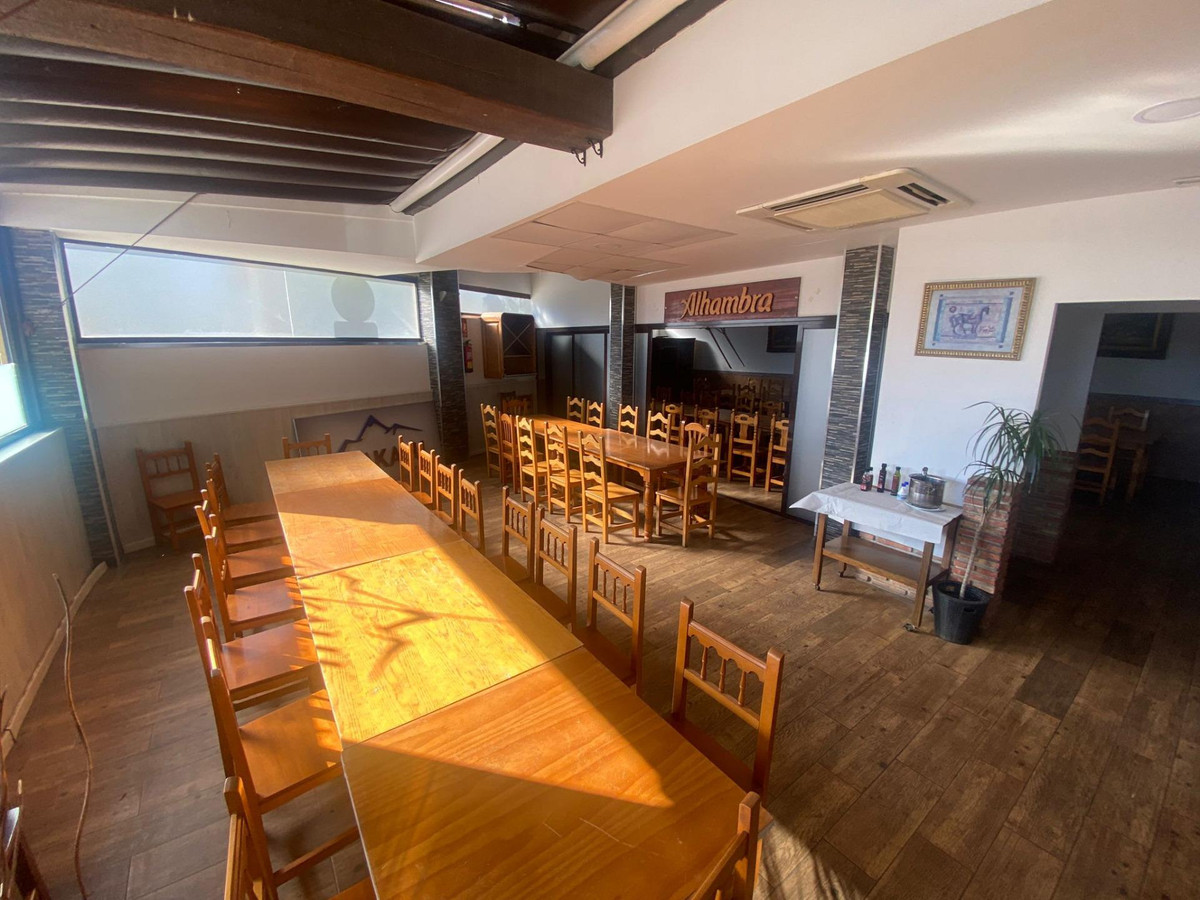 Restaurant interieur met houten tafels en stoelen.