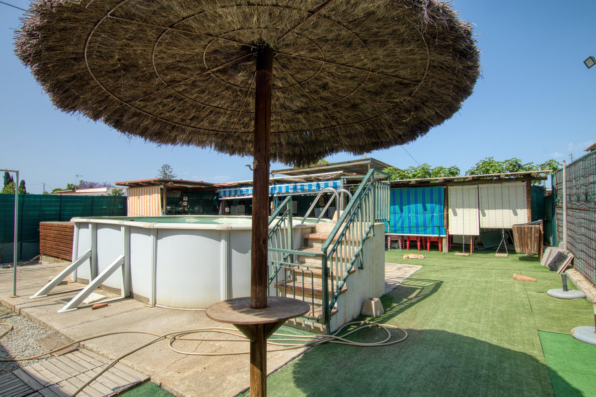 Achtertuin met zwembad, overdekt terras en groene kunstgrasmat