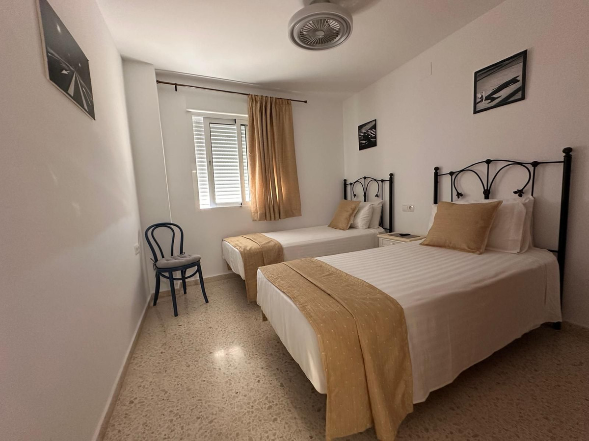 Slaapkamer met twee eenpersoonsbedden en neutrale inrichting.