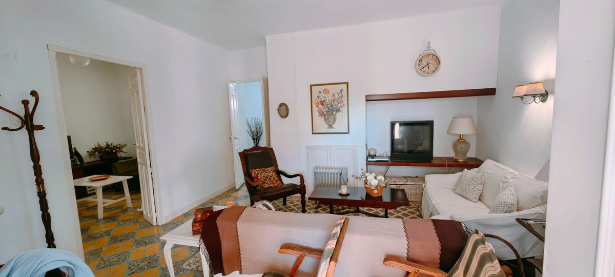 A cozy living room with classic furniture, a television, and artwork on the wall.