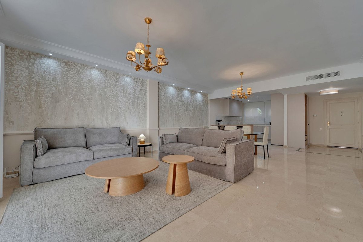 Modern living room with grey sofas, chandeliers, and open plan layout
