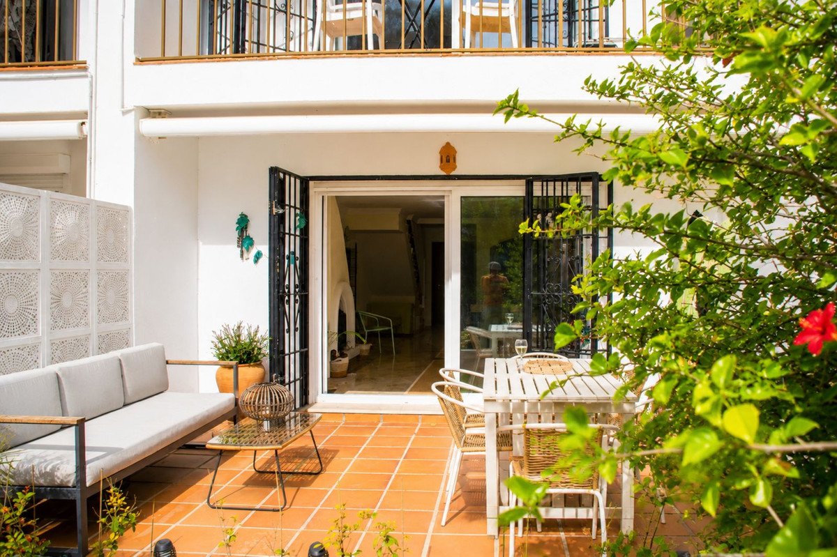 Terrace with outdoor dining set and sofa, leading into a living area with a fireplace.